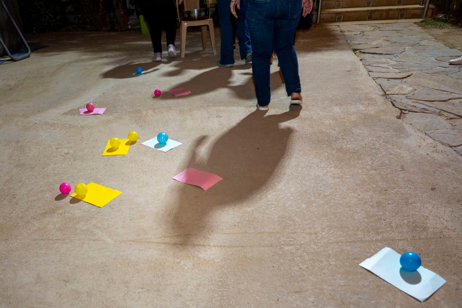 Maassa näkyy värillisiä papereita ja palloja, jotka ovat olleet osa ohjattua toimintaa kerhossa.