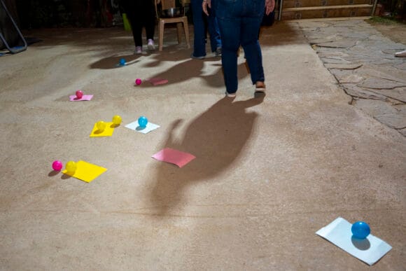 Maassa näkyy värillisiä papereita ja palloja, jotka ovat olleet osa ohjattua toimintaa kerhossa.