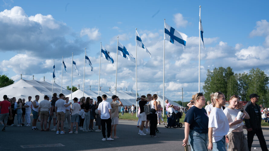 Ihmisiä ja suomenlippurivi tapahtumassa