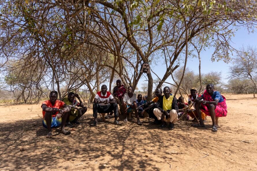 Pokot-miehiä istumassa puun varjoon kokoontuneena.