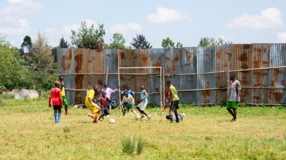 Kenialaisia poikia pelaamassa jalkapalloa Kawangwaren slummissa.
