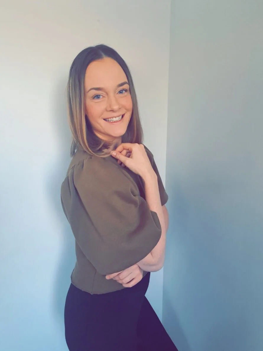 Nainen seisoo hymyillen