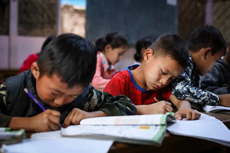 Students write to their notebooks in Myanmar.