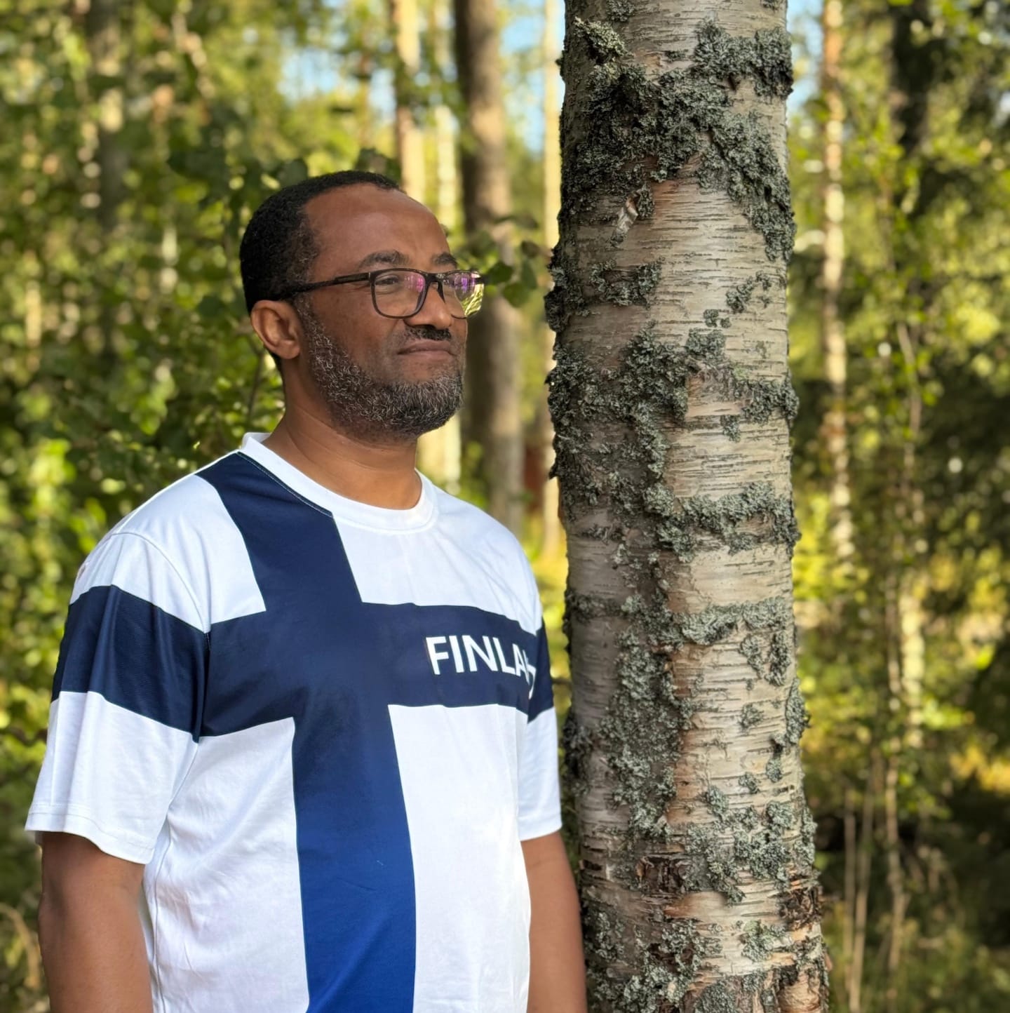 Etiopialainen mies, jolla on Suomen lippua muistuttava T-paita