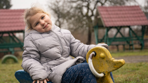 Pieni ukrainalaistyttö keinussa.