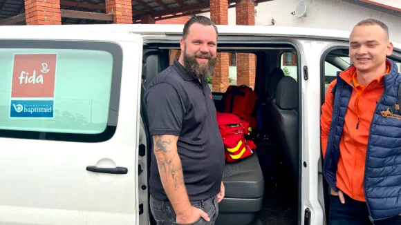 Two men are standing next to the van.