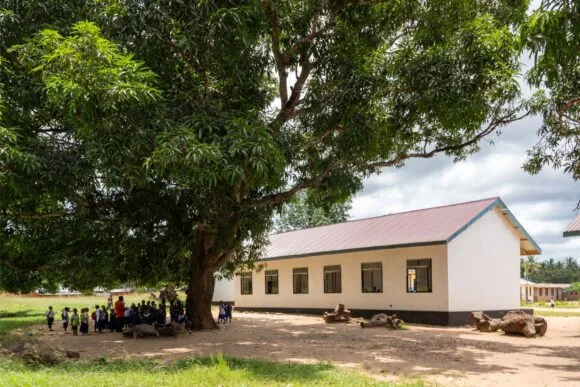 Students in front of a school and under a tree in Mtama, Tanzania.