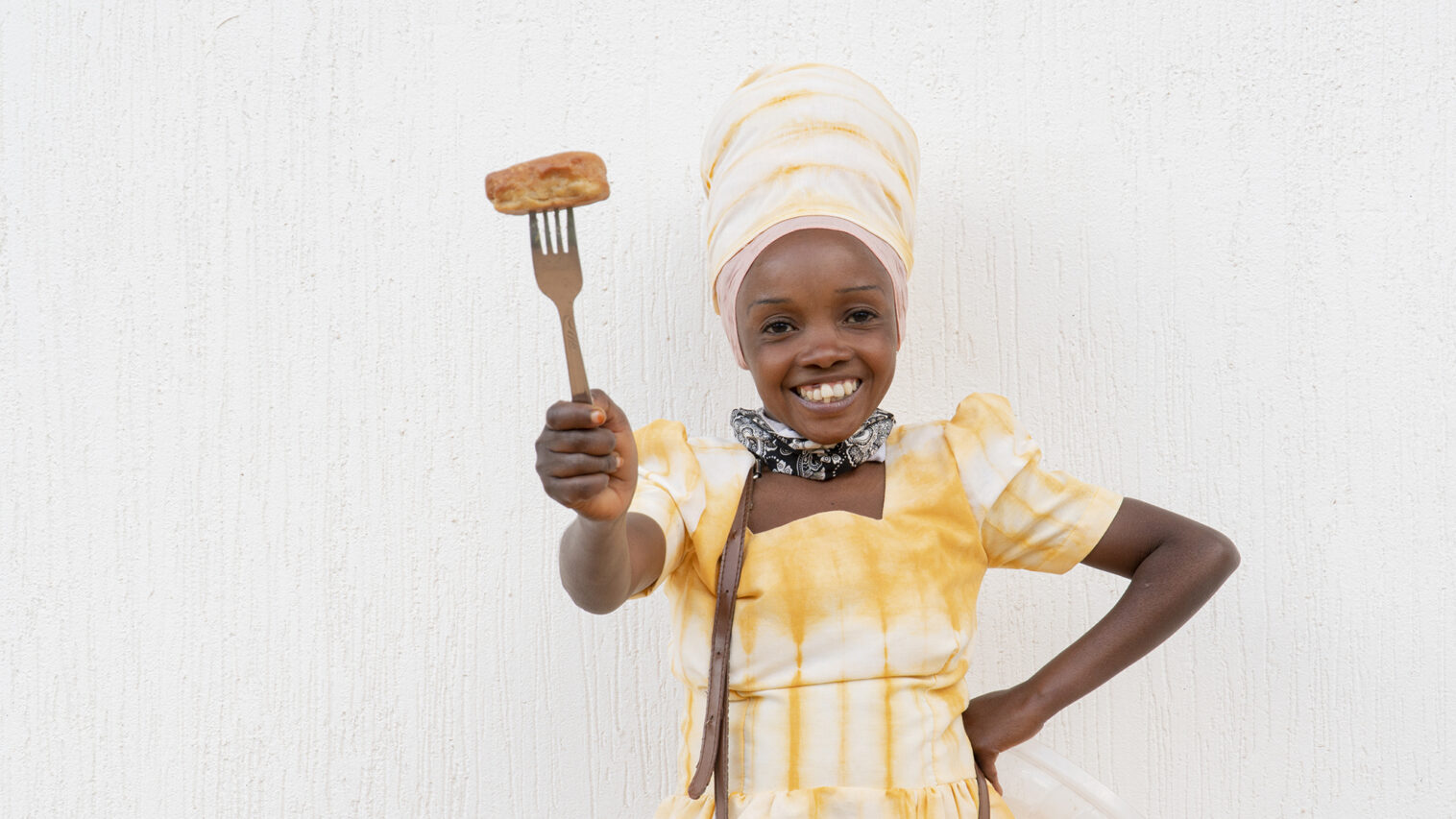 A woman smiles and holds a fork in her hand.